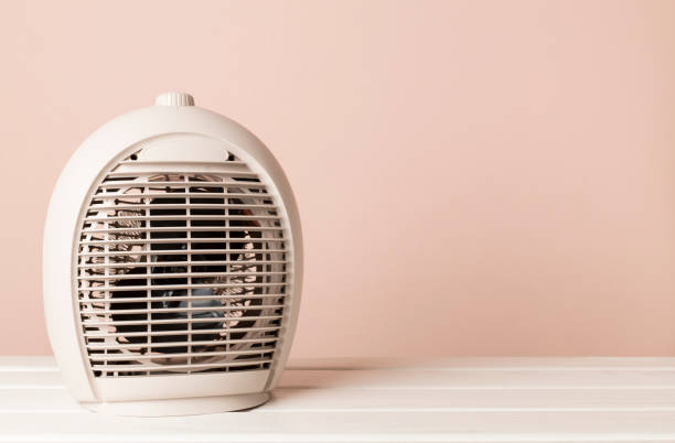 istock Portable electric heater on wooden table 2152966742