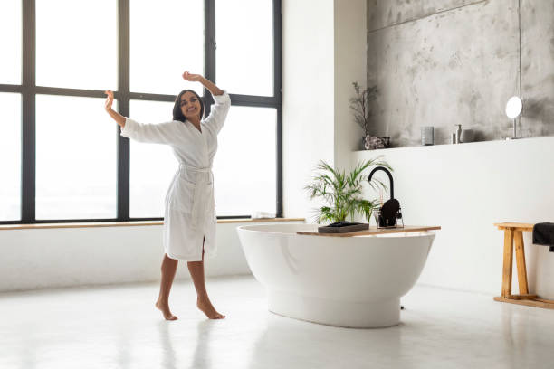 istock Carefree young indian woman wearing white bathrobe dancing 2152967287