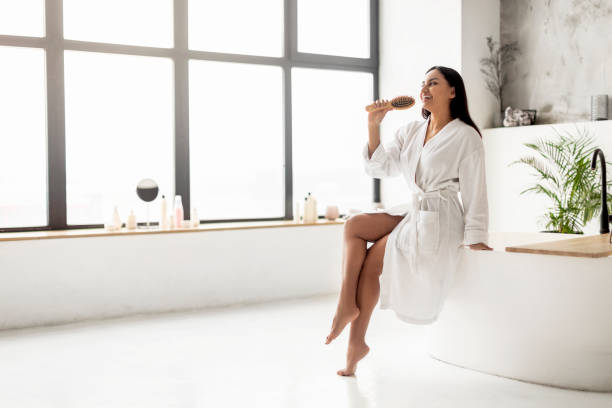istock Young indian woman in bathrobe singing while brushing hair 2152967313