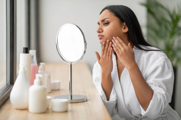 istock Upset young indian woman looking at mirror, touching her face 2152967399