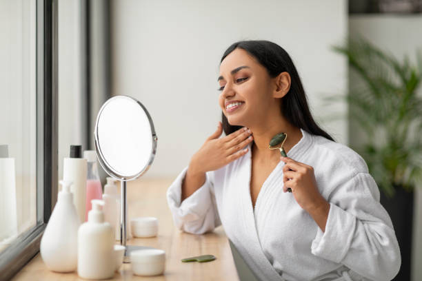 istock Beautiful indian lady massaging her neck with gua sha roller 2152967406