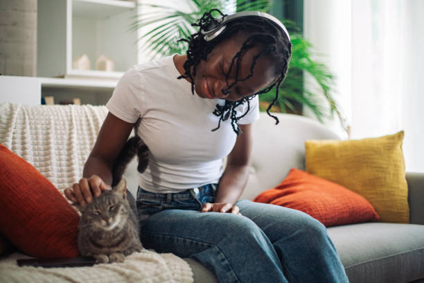 istock Woman petting cat on sofa, enjoying relaxation time 2152968895