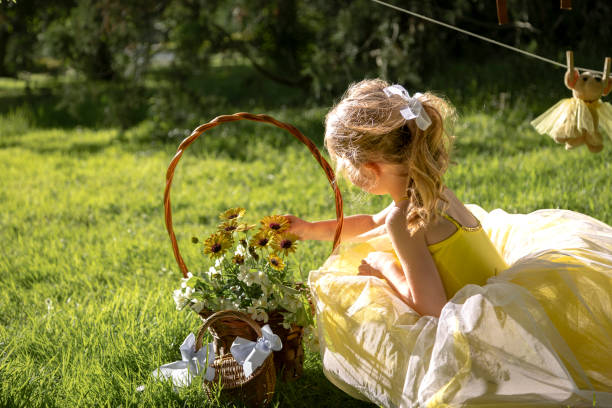 istock Child tends to flowers in a sunny garden setting. 2152968919
