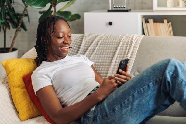 istock Young woman enjoying smartphone on couch 2152968963
