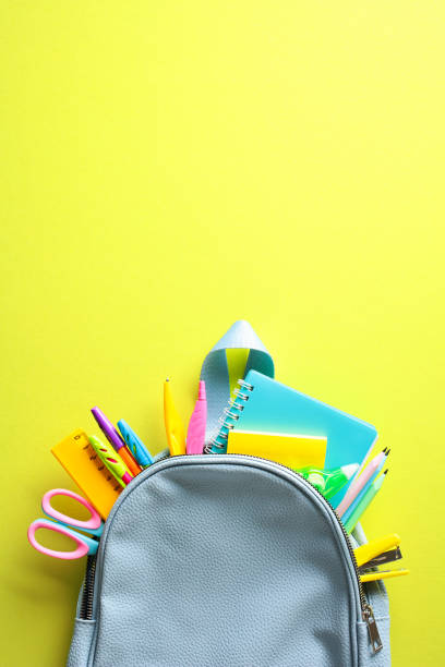 istock Colorful School Essentials - A blue backpack with vibrant school supplies on a bright yellow background. Ideal for back-to-school themes and creative projects 2152969166