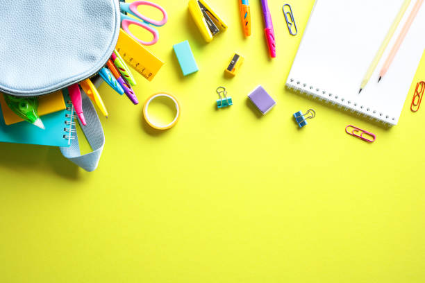 istock School Supplies: A colorful array of pencils, markers, and notebooks from a light blue backpack on a yellow backdrop. Ideal for educational promotions and stationery ads 2152969193