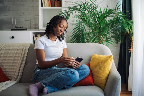 istock Casual woman using phone on cozy sofa 2152969901