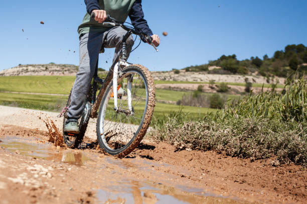 istock A boy is riding a bike on a muddy road 2152972021