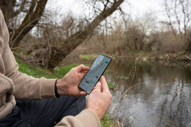 istock Investing while in Nature. Trader Relaxes at a Riverside. 2152977117