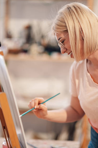 istock Side view of inspired artist painting on easel at creative art studio. 2152977288