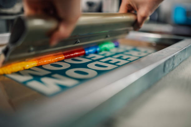 istock Close up of squeegee with ink on silkscreen printing plate at workshop 2152977289