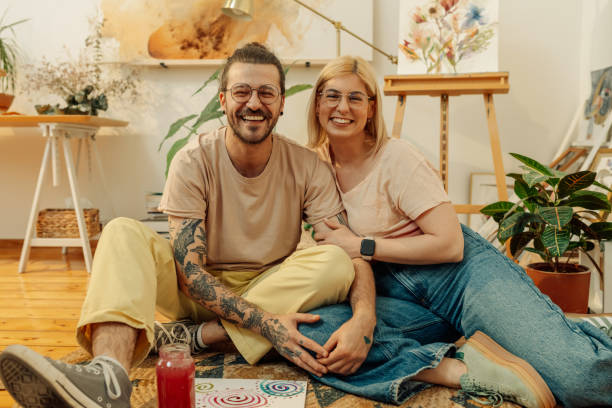 istock Romantic artistic couple sitting on atelier floor and hugging and smiling 2152977404