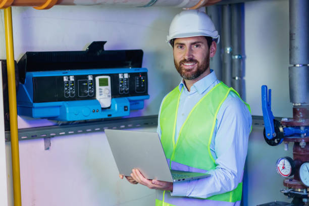 istock industrial engineer worker checking maintenance electric system on laptop computer at plant room look at camera smiling 2152977998