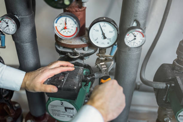 istock Repairman hand fixing a hot water pipe in the technical area of heating system 2152978007
