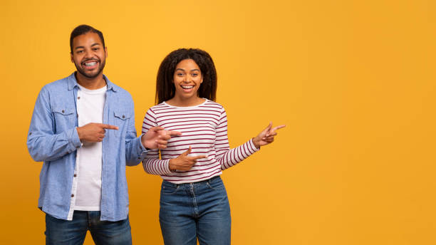 istock Nice Offer. Happy Black Couple Pointing Aside With Fingers, Indicating Copy Space 2152985222