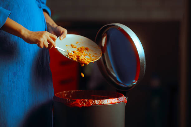 istock Woman Throwing Away Dinner Leftover Food in the garbage Bin 2152985321