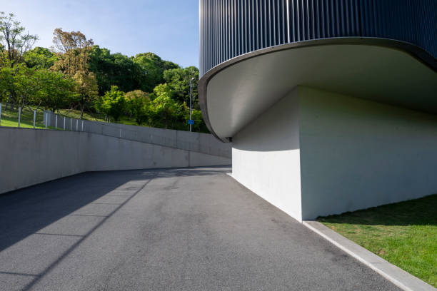 Sunlight shining on asphalt road in front of modern building