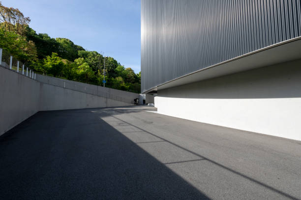 Sunlight shining on asphalt road in front of modern building