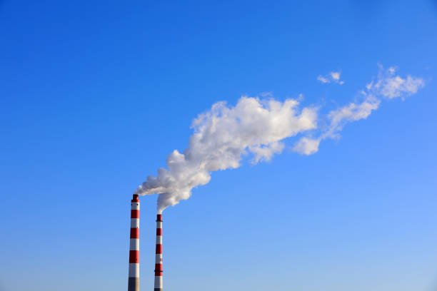 The chimney that emits smoke and dust in the blue sky