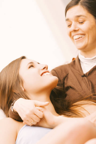Affectionate embrace shared by daughter and mother, who shows a humorous expression in response