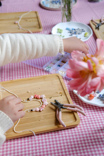 istock Set of multi-colored ceramic and plastic beads for needlework, child and mother are making jewelry at home. Easy and creative craft for children and teenagers. Making bracelets or necklace DIY. 2152995350