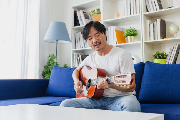 istock Man enjoy playing guitar at home in living room. 2152997672