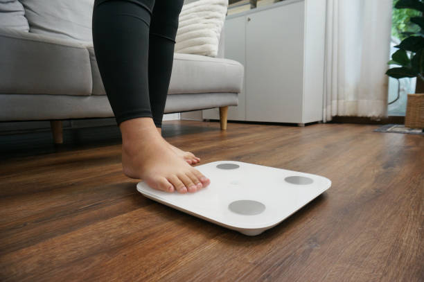 istock Fat diet and scale feet standing on electronic scales for weight control. 2152999821