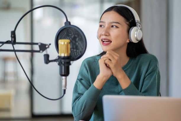 istock Modern young woman chatting and recording podcasts in studio 2153000483