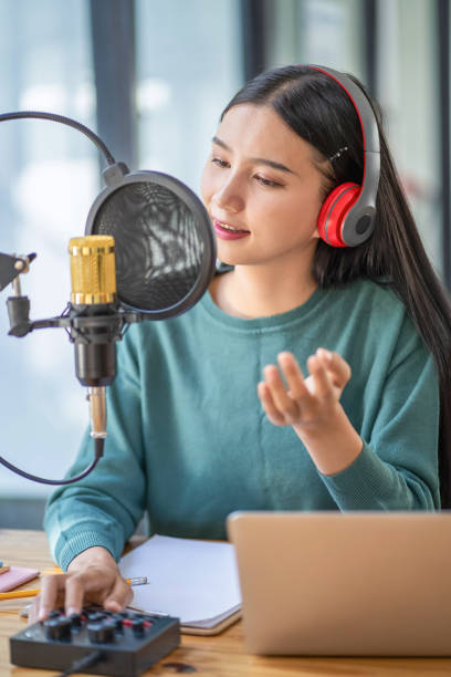 istock Modern young woman chatting and recording podcasts in studio 2153000585