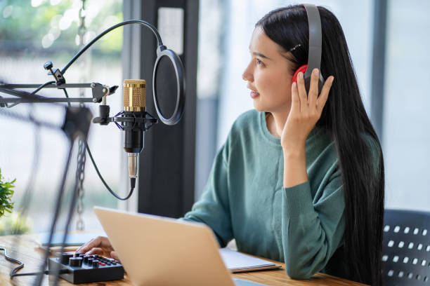 istock Modern young woman chatting and recording podcasts in studio 2153000587