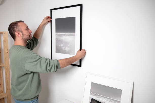 istock Man hanging pictures on the wall. 2153003914