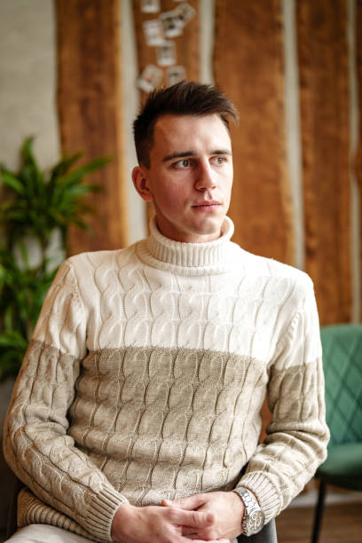 istock Man Sitting in Chair Wearing Sweater 2153007759