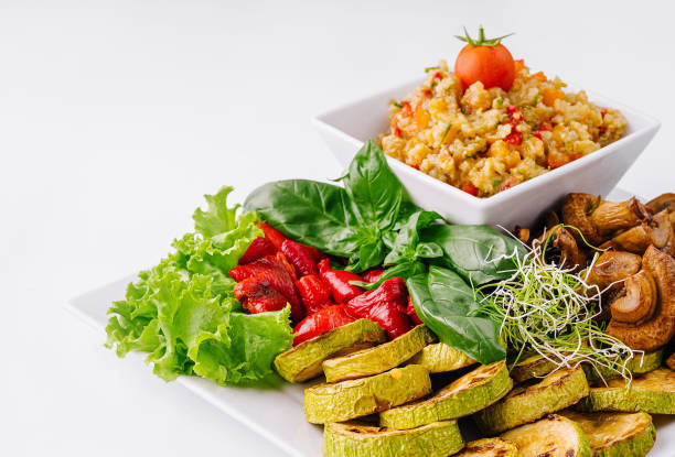 Vibrant plate of mixed grilled vegetables and salad on a crisp white background