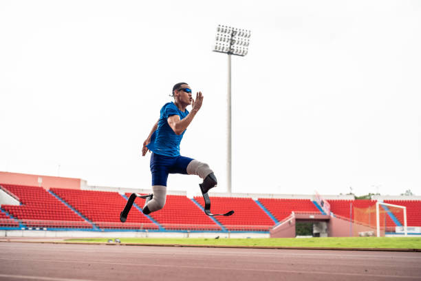 istock Asian para-athletes disabled with prosthetic blades running at stadium. Attractive amputee male runner exercise and practicing workout for Paralympics competition regardless of physical limitations. 2153009733