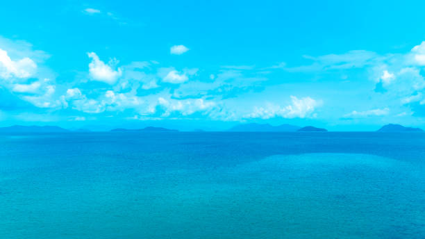 Background for summer vacation concept. Beach nature and summer seawater with sunlight light sandy beach Sparkling sea water contrast with the blue sky.