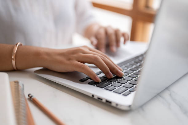istock A close-up image of a woman typing on keyboard, working on the computer at a table in a coffee shop. 2153011849