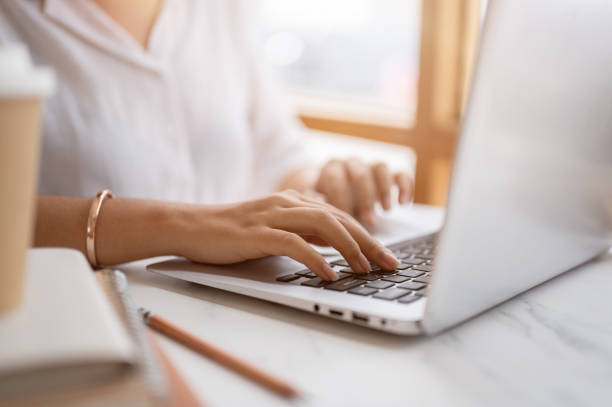 istock A close-up image of a woman typing on keyboard, working on the computer at a table in a coffee shop. 2153011867