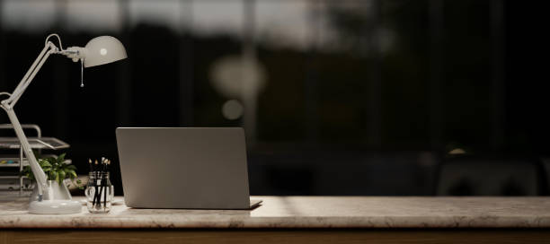 istock A laptop computer on a marble table in a modern dark office at night. 2153012538