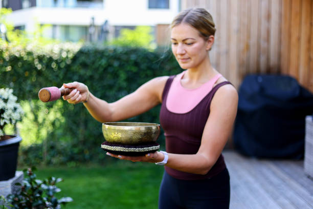 istock woman playing singing copper bowl outdoors while meditating 2153014527