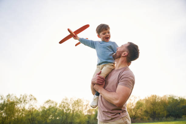 istock Father is holding son that playing with toy plane 2153015562