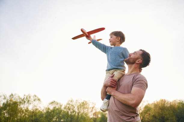 istock Father is holding son that playing with toy plane 2153015570