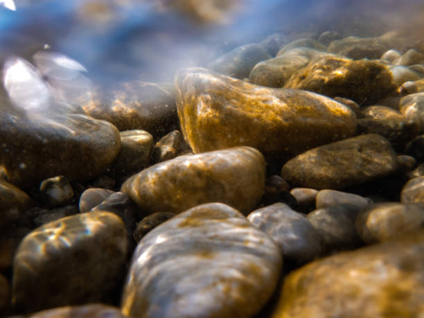 istock Pebbles stone underwater below water surface near lake shore, natural scene 2153015890
