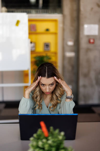 Businesswoman suffering from headache on workplace