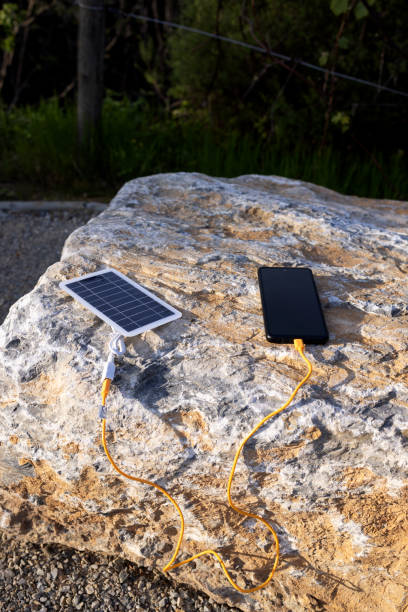 istock The mobile phone is charged from a portable solar panel outside. 2153017919