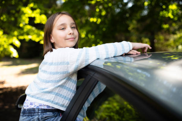 On a sunny weekend, the whole family goes to the countryside. After pulling up under some trees, they try to find the right place to park and start the walk. The little girl climbs up the window to admire the scenery.