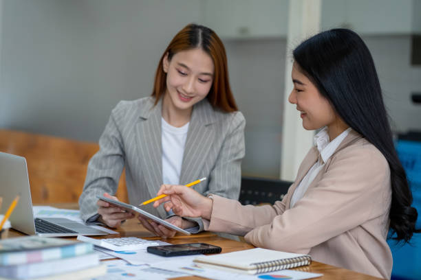 istock Two Asian businesswomen working Creative discussion in office using laptop and tablet, business concept 2153019108