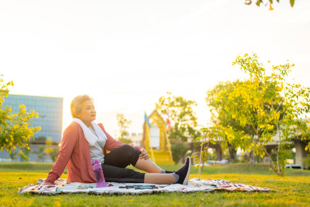 Cheerful active senior woman exercising at park