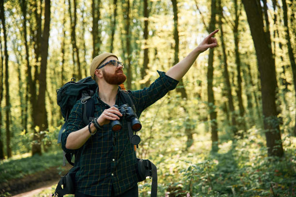 istock Tourist with binoculars. Bearded man is in the forest at daytime 2153021544