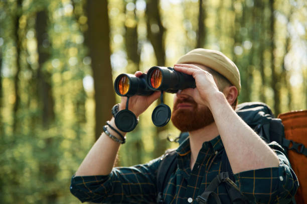 istock Tourist with binoculars. Bearded man is in the forest at daytime 2153021564