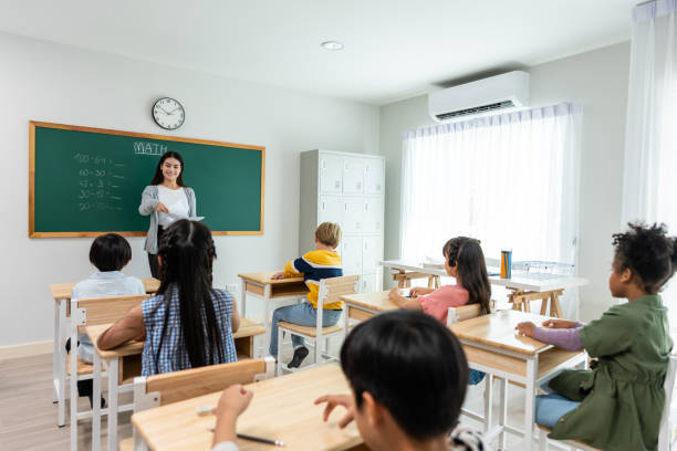 istock Group of student learn with teacher in classroom at elementary school. Attractive beautiful female instructor master explain and educate young children with happiness and fun activity at kindergarten. 2153021599